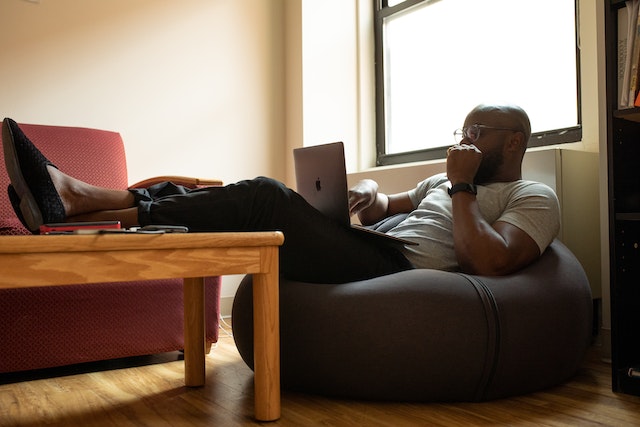 person sitting on a bean bag chair with their feet on the table